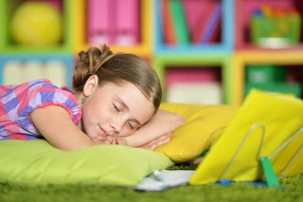 Retrato de uma estudante cansada dormindo no livro de exercícios