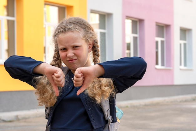 Foto retrato de uma estudante no fundo da escola conceito dias escolares de volta à escola garota de uniforme com uma mochila aluno aluno estudioso