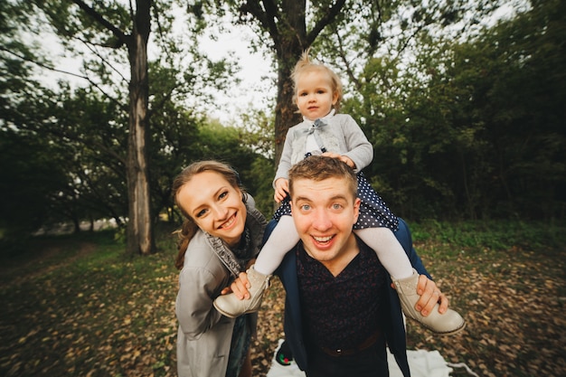 Retrato de uma família alegre se divertindo ao ar livre