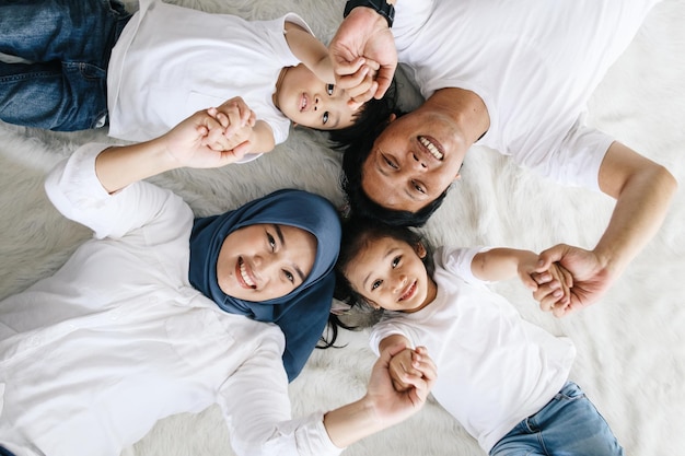 Retrato de uma família asiática feliz deitada no chão em casa