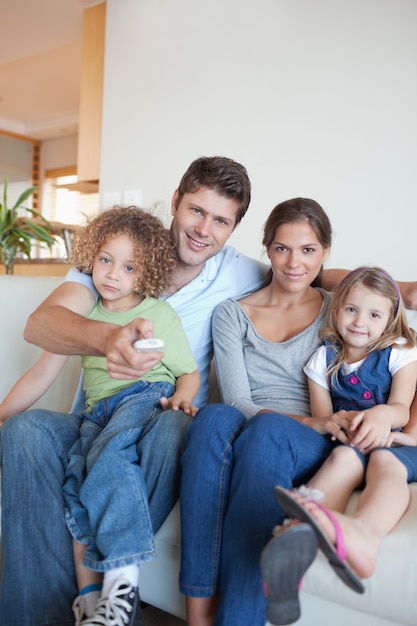 Foto retrato de uma família assistindo televisão juntos