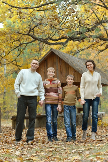 Foto retrato de uma família de quatro pessoas na floresta de outono