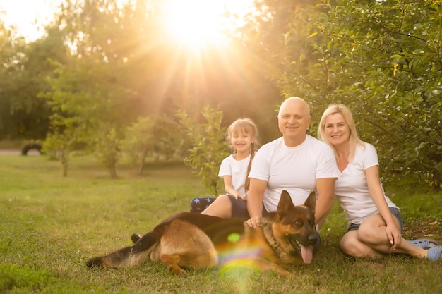 Retrato de uma família extensa com seu cão de estimação sentado no parque