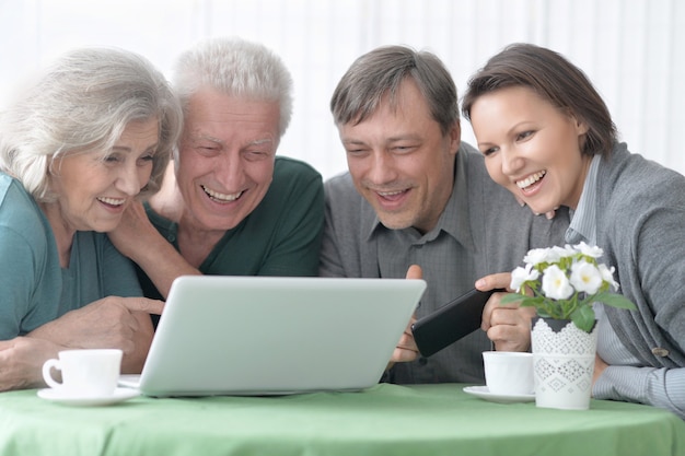 Retrato de uma família feliz e sorridente com um laptop