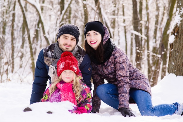 Retrato de uma família feliz posando na floresta de inverno