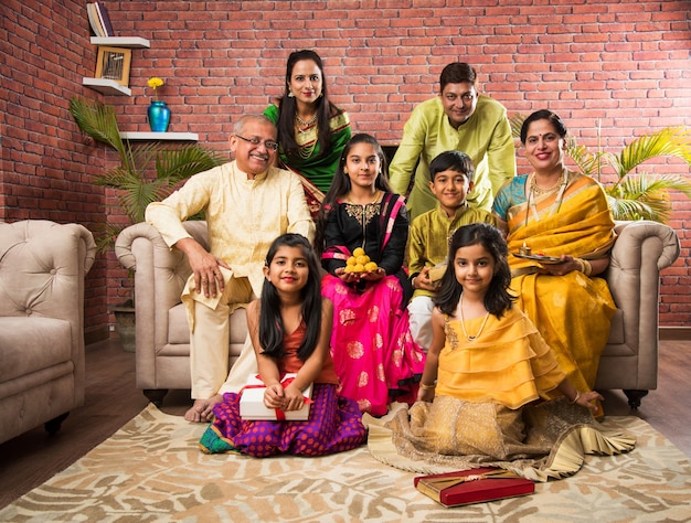 Retrato de uma família indiana feliz em trajes tradicionais, sentado no sofá interno