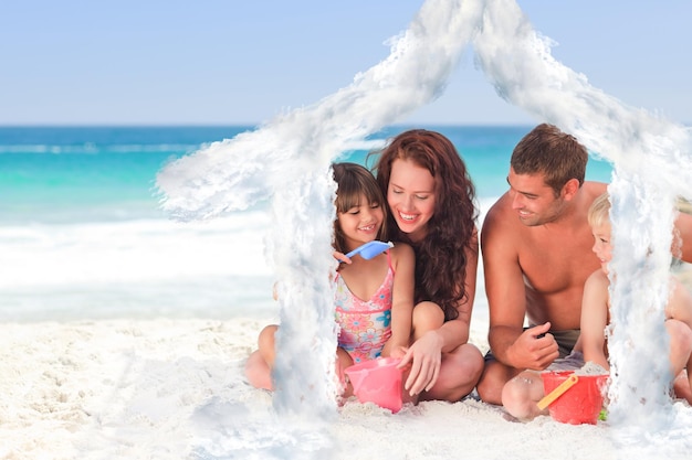 Retrato de uma família na praia contra o contorno da casa nas nuvens