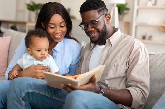 Retrato de uma família negra feliz lendo livro para criança