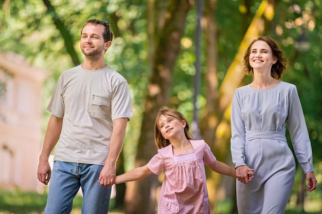 Retrato de uma família tradicional feliz em um passeio em um parque de verão, vista de trás sem rosto