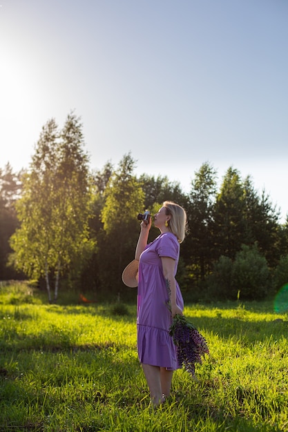 Retrato de uma foto de menina em um campo florido ao sol ao pôr do sol