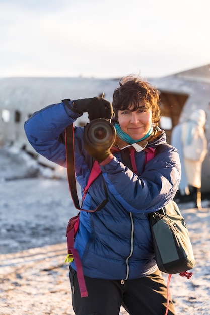 Retrato de uma fotógrafa aventureira sorrindo no inverno na Islândia no avião em Solheimasandur