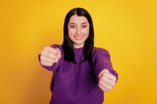 Retrato de uma garota atraente adorável, muito charmosa, alegre, girando o volante isolado em um fundo de cor amarela brilhante