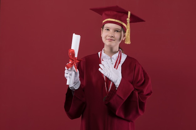 Retrato de uma garota graduada em um boné de formatura em um fundo vermelho