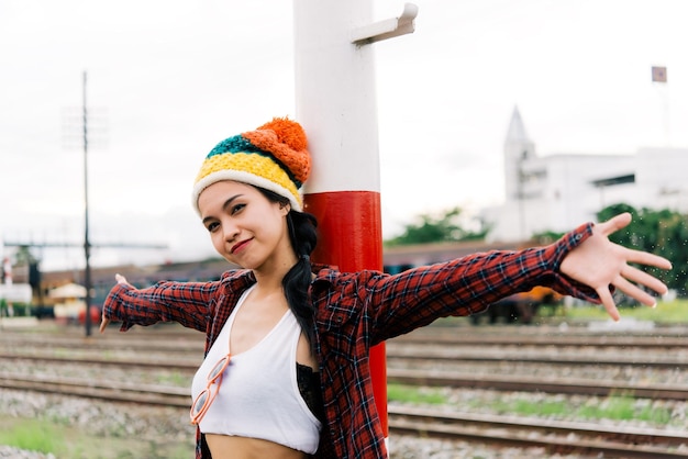 Retrato de uma garota hipster sentada na ferrovia estilo vintage mulher tailandesa posando para tirar uma foto