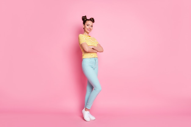 Retrato de uma garota posando com a coleção de roupas de braços cruzados isolada em um fundo de cor rosa