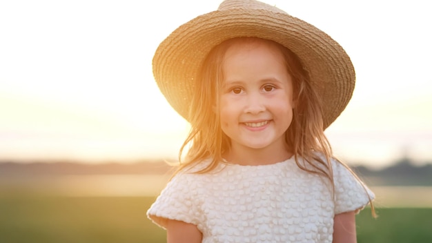 Retrato de uma garotinha feliz no chapéu de palha sorrindo de perto