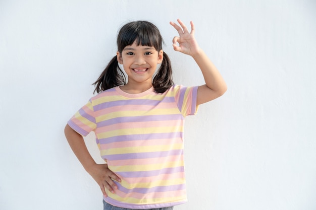 Retrato de uma garotinha fofa mostrando um gesto de aprovação