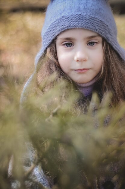 Retrato de uma garotinha vestida estilo vintage brincando na floresta