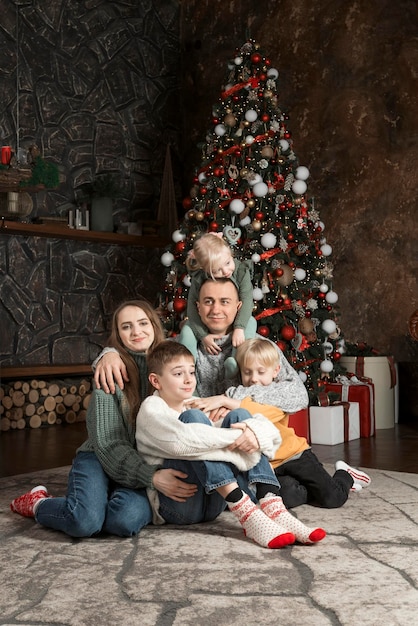 Retrato de uma grande família feliz em casa perto da árvore de Natal Três filhos e pais Família Véspera de Natal