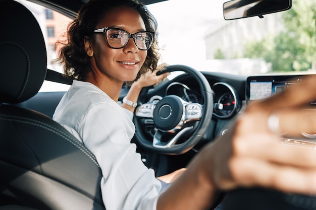 Foto retrato de uma jovem a conduzir um carro