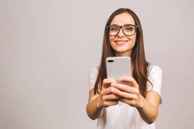 Retrato de uma jovem adolescente feliz vestida com telefone celular