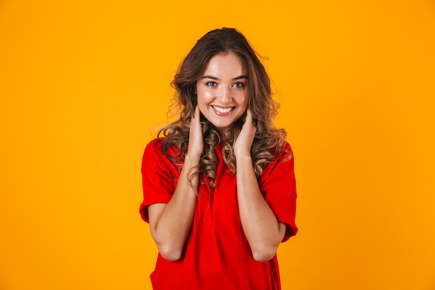 Retrato de uma jovem adorável alegre brincalhão isolado na parede amarela, posando