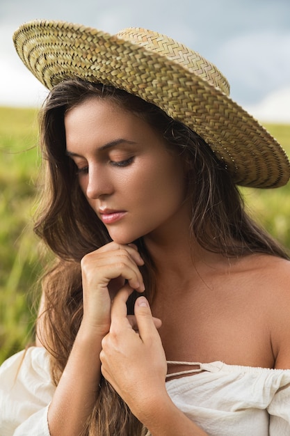 Retrato de uma jovem adorável com chapéu de palha no campo de arroz