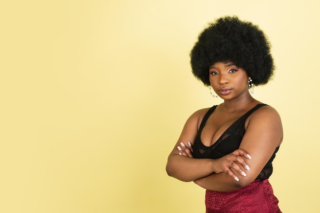 Retrato de uma jovem africana isolada sobre o fundo amarelo claro do estúdio Conceito de emoções humanas expressão facial anúncio de vendas para jovens