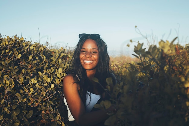 Retrato de uma jovem alegre de pé no meio de plantas