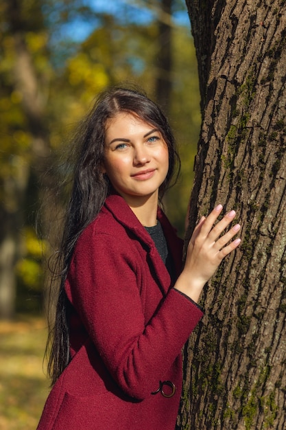 Retrato de uma jovem alegre, desfrutando no parque outono.