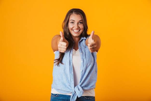 Foto retrato de uma jovem alegre e casual, mostrando o gesto de polegar para cima