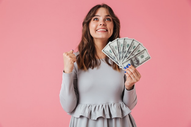 Foto retrato de uma jovem alegre segurando notas de dinheiro