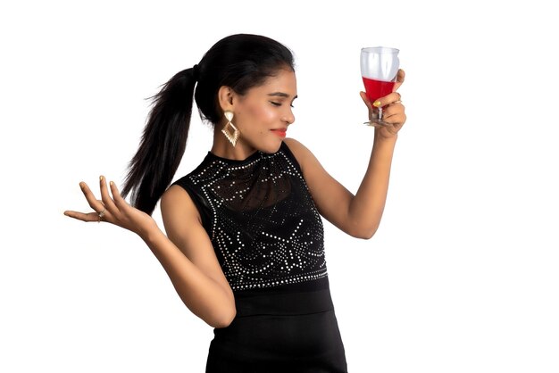 Foto retrato de uma jovem alegre segurando um copo de vinho isolado sobre fundo branco