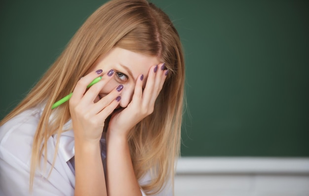Retrato de uma jovem aluna envergonhada com vergonha estudando na sala de aula da escola