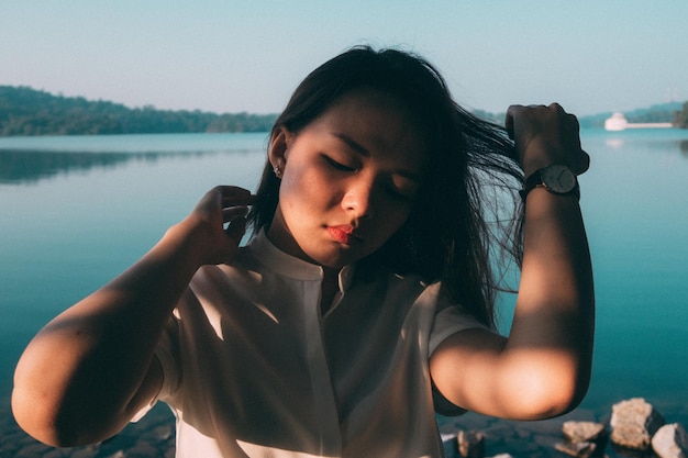 Retrato de uma jovem ao lado de um lago