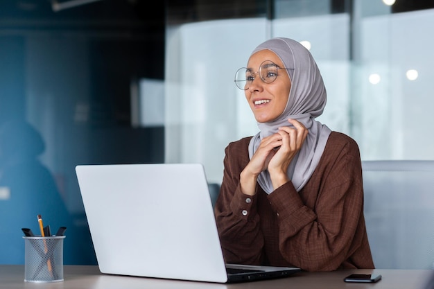 Retrato de uma jovem árabe em um blogueiro freelancer hijab sentado no escritório no