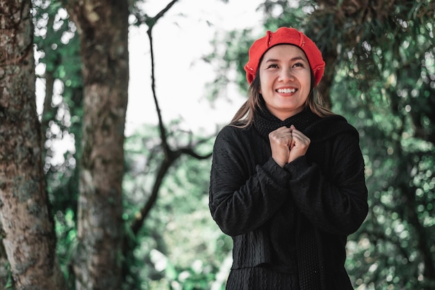 Retrato de uma jovem asiática em traje de inverno rezando de manhã na floresta Cristianismo e fé esperança amor conceito