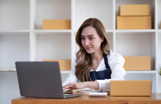 Retrato de uma jovem asiática pme trabalhando com uma caixa em casa o local de trabalhostartup proprietário de pequenas empresas empreendedor de pequenas empresas pme ou negócios freelance on-line e conceito de entrega