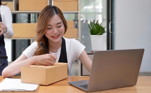 Retrato de uma jovem asiática PME trabalhando com uma caixa em casa o local de trabalhostartup proprietário de pequenas empresas empreendedor de pequenas empresas PME ou negócios freelance on-line e conceito de entrega