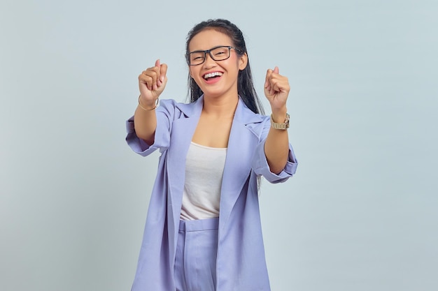Retrato de uma jovem asiática sorridente mostrando sinal de coração coreano com dois dedos cruzados, expressando alegria e positividade isoladas no fundo branco