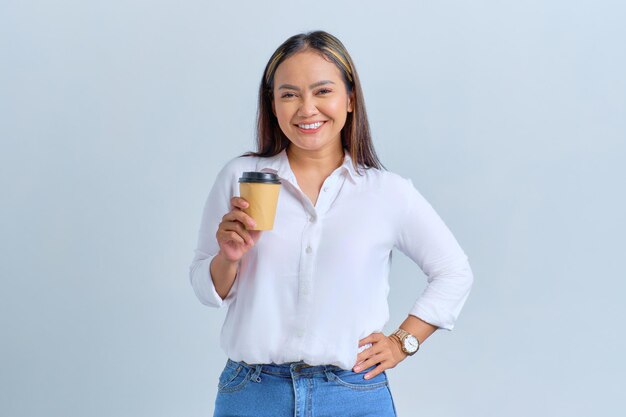 Retrato de uma jovem asiática sorridente segurando uma xícara de café de papel isolada sobre fundo branco