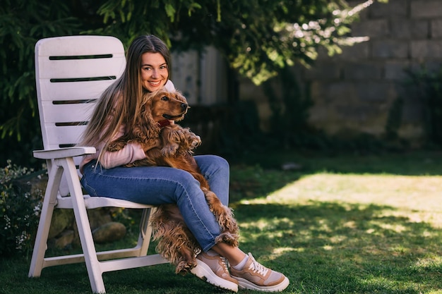 Retrato de uma jovem atraente abraçando cocker spaniel fofo eu