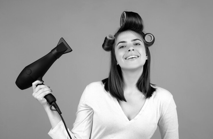 Foto retrato de uma jovem atraente com secador de cabelo uma garota bonita com cabelo reto secando o cabelo com um secador de cabelos profissional