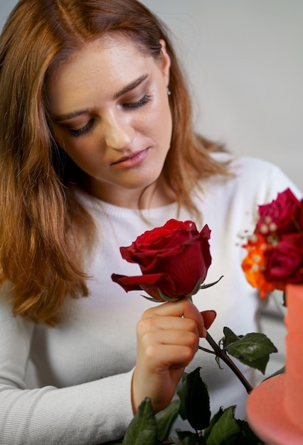 Retrato de uma jovem atraente segurando buquê de rosas isoladas no fundo branco