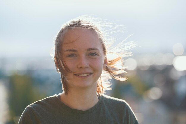 Retrato de uma jovem atraente sorrindo em dia ensolarado ao ar livre