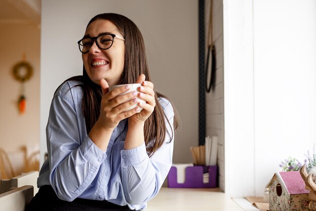 Foto retrato de uma jovem bebendo café em casa