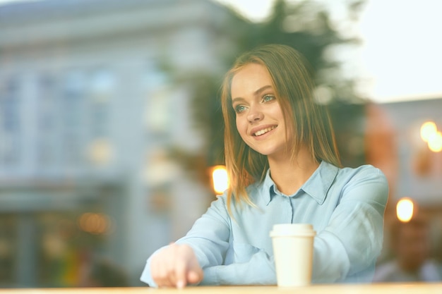 Retrato de uma jovem bebendo café em um café