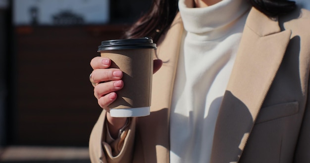 Retrato de uma jovem bebendo café para viagem Closeup mulher relaxante com café para ir