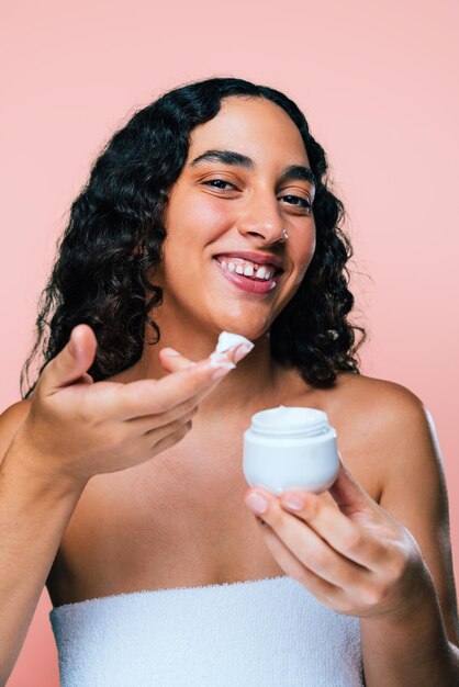 Foto retrato de uma jovem bebendo um copo contra um fundo rosa