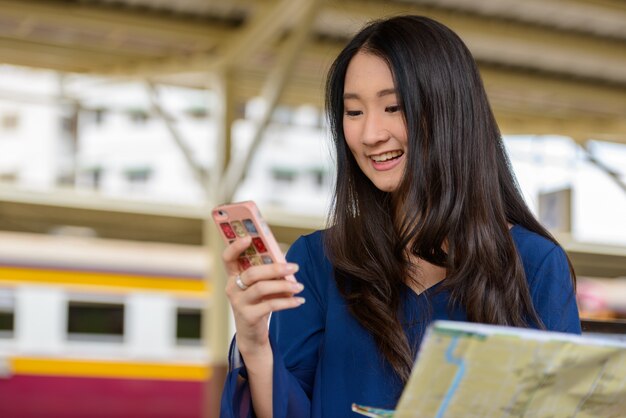 Retrato de uma jovem bela turista asiática na estação ferroviária hua lamphong em bangkok